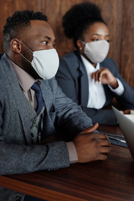 Professionals in modern attire wearing masks in a corporate setting
